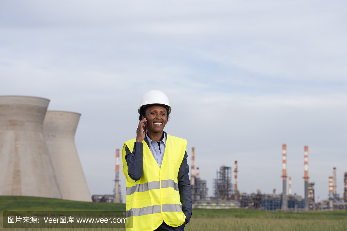 在化工廠打電話的女商人。